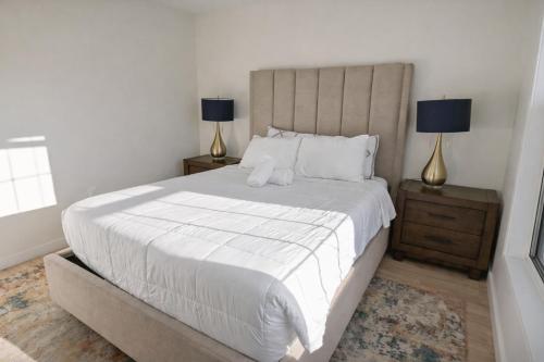 une chambre avec un grand lit blanc avec deux lampes dans l'établissement Warm and Bright Home, Metro 1 Min Walk, à Capitol Heights
