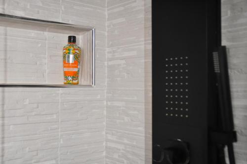 a bottle of orange soap in a niche in a bathroom at Appartamenti "UNIQUE" palazzo storico FAENZA in Faenza