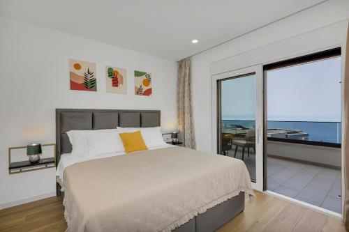 a bedroom with a bed and a view of the ocean at Villa Bacula in Veliko Brdo