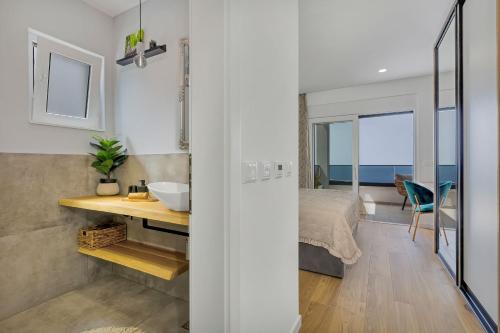 a bathroom with a sink and a bedroom with a bed at Villa Bacula in Veliko Brdo