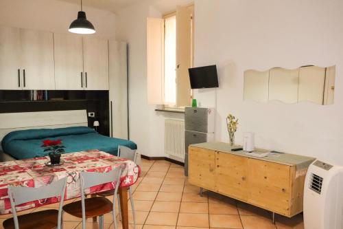 un soggiorno con un tavolo e un divano di porta merlonia house grazioso monolocale a Forlì