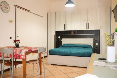 una camera da letto con un letto e un tavolo e un tavolo e un tavolo di porta merlonia house grazioso monolocale a Forlì
