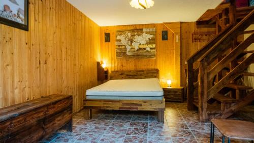 Un dormitorio con una cama en una habitación con paredes de madera. en Chalet alpin authentique au cœur du Valais, Hérémence, en Saint-Martin
