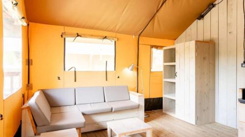 代讷坎普Papillon Country Resort的客厅里有一张沙发和一张桌子。