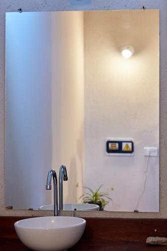 a bathroom with a sink and a mirror at Posada del Paraíso-Exclusivo adultos in Las Rabonas