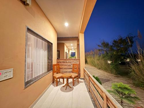 NārāyanpurThe Cub Sariska的阳台配有桌子和两把椅子