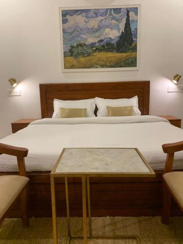 a bedroom with a large bed with a table at The Cub Sariska in Nārāyanpur