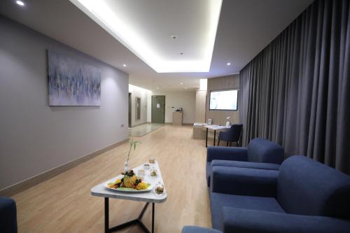 un soggiorno con un divano blu e un tavolo di Best Western Premier Riyadh a Riyad