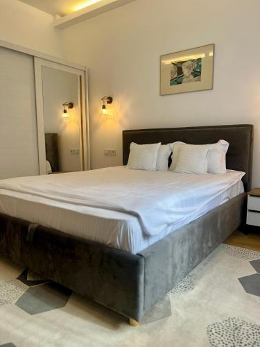 a large bed with white sheets in a bedroom at Parc Vatra Dornei - Deluxe Suite in Vatra Dornei