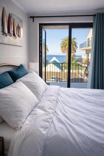 a bedroom with a bed with a view of the ocean at Marina Views Simon's Town, Near Long Beach in Simonʼs Town