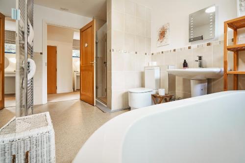 een witte badkamer met een wastafel en een toilet bij Glenardle Lodge in Bridge of Cally