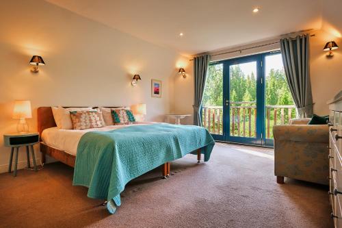 een slaapkamer met een bed en een groot raam bij Glenardle Lodge in Bridge of Cally