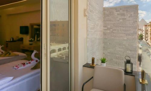 una stanza con una finestra con una sedia e una camera da letto di rizkyan pyramids view INN a Il Cairo