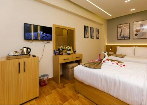 una camera con 2 letti, una scrivania e una TV di rizkyan pyramids view INN a Il Cairo