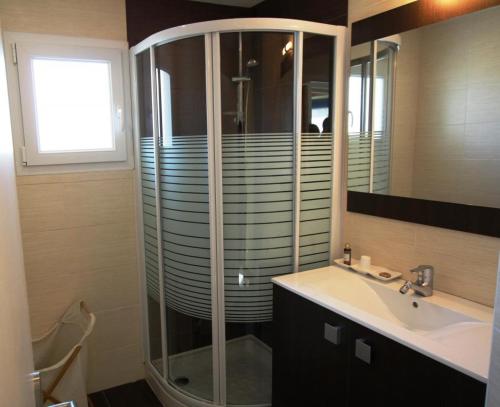 een badkamer met een glazen douche en een wastafel bij La maison de madeleine in Livron