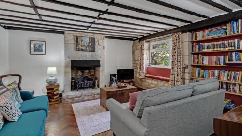 a living room with a couch and a fireplace at Whitehall Cottage in Painswick