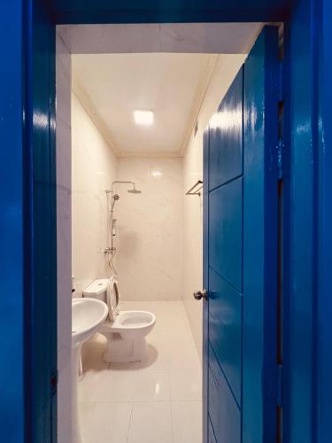 a bathroom with a white toilet and a sink at Nautical Nook Maldives in Kendhoo