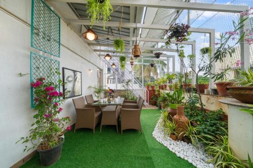 ein Restaurant mit Pflanzen, Tischen und Stühlen in der Unterkunft Twilight Terrace 3BHK Spacez Villa with Private Theatre in Bangalore