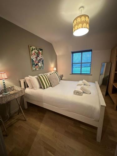 a bedroom with a large white bed and a lamp at Woodland View House in Norton Canon