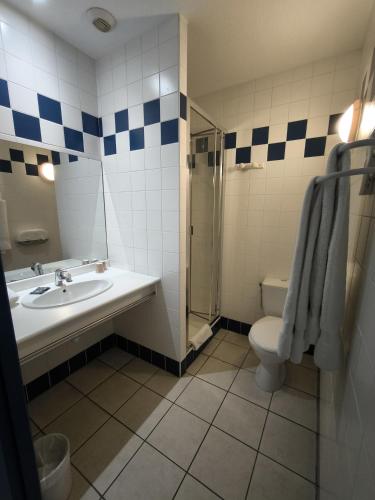 a bathroom with a sink and a toilet and a shower at Hôtel Le Laury's-hôtel calme proche de Rodez avec parking privé gratuit-Arrivée après 20h possible via borne automatique in Onet le Château