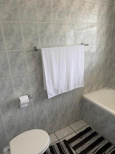 a bathroom with a toilet and a white towel at Crest Premium in Johannesburg