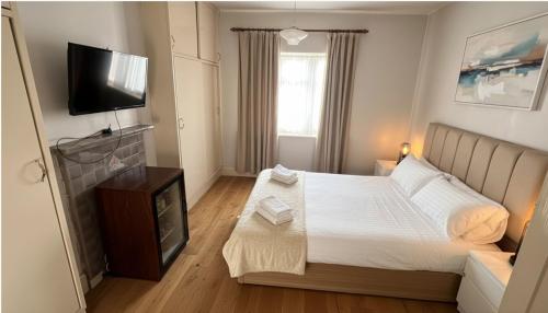 a bedroom with a bed and a flat screen tv at The London Residence in Enfield