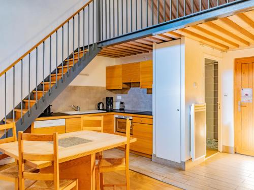 eine Küche mit einem Holztisch und einer Treppe in der Unterkunft Mas de la Barque in Gourdouze