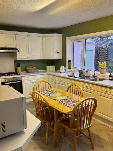 a kitchen with a wooden table and chairs and a sink at St Martin’s view in Haverfordwest
