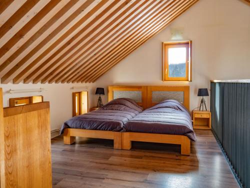 ein Bett in einem Zimmer mit Holzdecke in der Unterkunft Mas de la Barque in Gourdouze