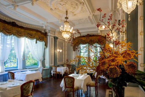 a dining room with tables and chairs and a vase of flowers at Hotel Chourakukan Kyoto Gion in Kyoto