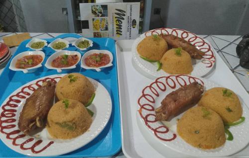 due vassoi di cibo su un tavolo con piatti di Monique CZ Abomey Plage ad Abomey