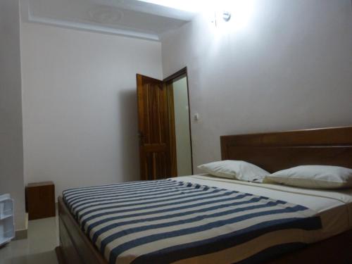 a bedroom with a bed with a blue and white striped blanket at Villa Savana in Saly Portudal