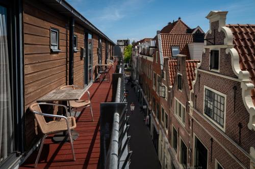 a balcony with tables and chairs on a city street at St Christopher's Inn Amsterdam - The Winston in Amsterdam