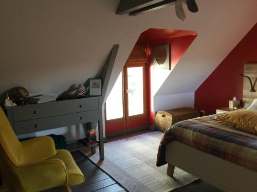 a bedroom with a bed and a chair and a window at Le petit secret au pied du zoo in Saint-Aignan