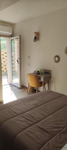 a bedroom with a bed and a table and a door at Casa Alysa Agriturismo in Tavullia
