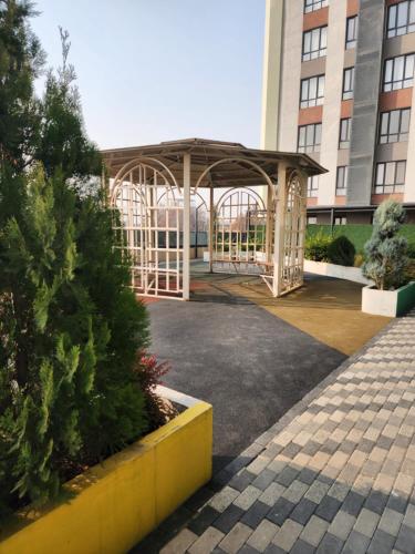 un gazebo di fronte a un edificio di Prestige Apartament a Tashkent