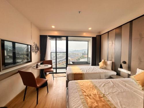 a hotel room with two beds and a table and chairs at Phương hotel Lyn Time Thanh Thuỷ in La Phu