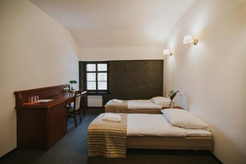 a hotel room with two beds and a desk at Zamek Bożejów - Kuźnia in Radomierowice