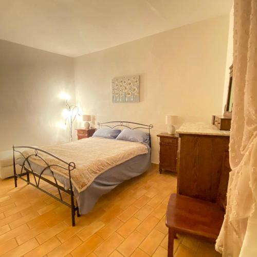 a bedroom with a bed and a wooden floor at La Dimora di Dida in Seggiano
