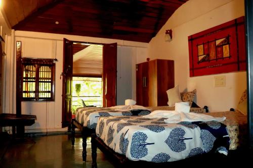 ein Schlafzimmer mit zwei Betten und einem Fenster in der Unterkunft Ayurprana Marari in Mararikulam