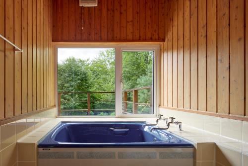 a kitchen with a blue sink and a window at Tokachi Mikage forest villa in Mikage