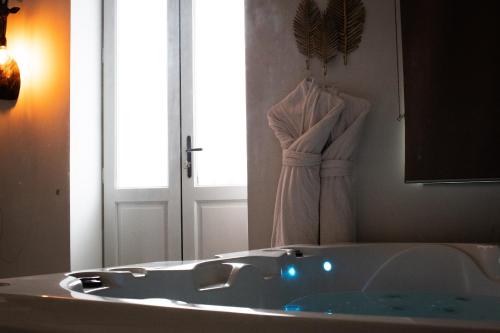 een badkamer met een ligbad en een spiegel bij Bordeaux Suites & Spa in Bordeaux