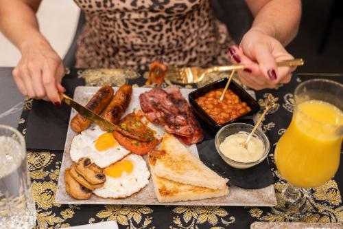 un vassoio di prodotti per la colazione con uova e altri alimenti di HH Riz Resort - Adults Only a Maspalomas