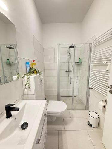a white bathroom with a shower and a toilet at Moderner Neubau nähe Lübeck in Stockelsdorf