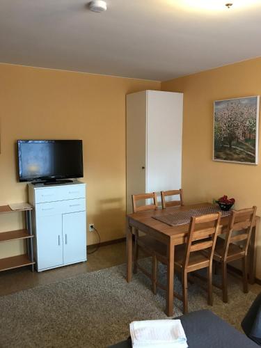 a living room with a table and a tv and a table and chairs at Hedemora Logi in Hedemora