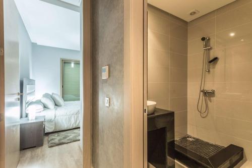 a bathroom with a shower and a bedroom with a bed at Prestigia 16 in Marrakesh