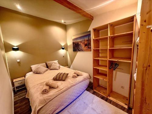 a small bedroom with a bed and shelves at Evergreen -Ocean and Spa- in Parentis-en-Born