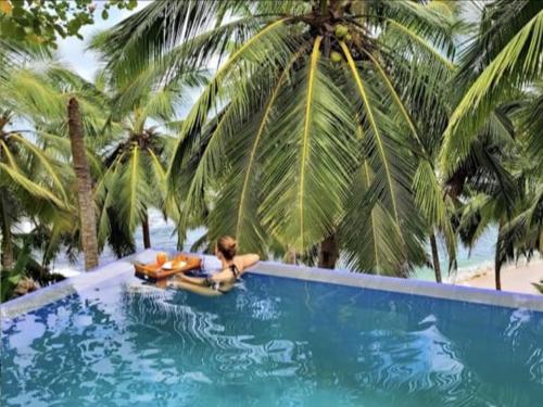 een vrouw op een surfplank in een zwembad bij Goyambokka Beach front pool resort in Tangalle