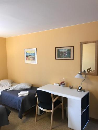 a bedroom with a bed and a desk and a table at Hedemora Logi in Hedemora