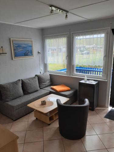 a living room with a couch and a table at Ferienbungalow Fleesensee in Malchow